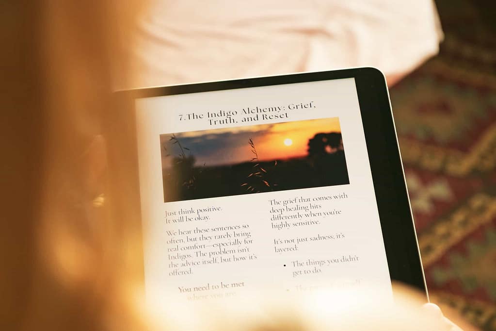 Tanimara Layla holding an iPad displaying The Indigo Healing Guide — a nervous system healing guide and memoir for highly sensitive souls — smiling softly as she shares the manual she once needed herself.